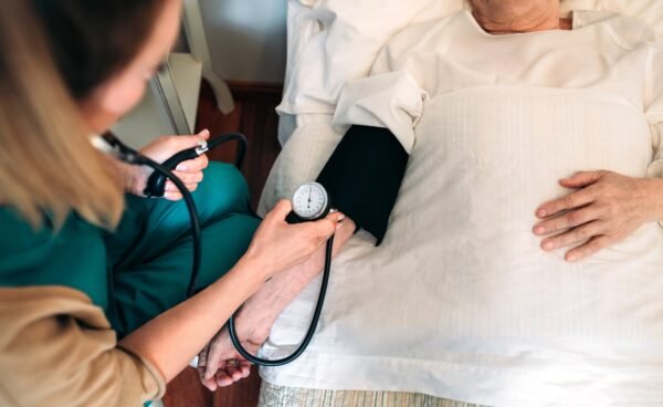 Caregiver checking blood pressure to a senior woman Caregiver checking blood pressure to a senior woman